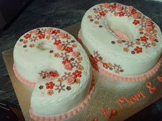 two decorated cakes sitting on top of a cake platter with the number 50 written in white frosting