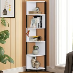 a corner shelf with books on it in a living room next to a potted plant