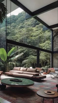 a living room filled with lots of furniture next to a forest covered mountain side wall