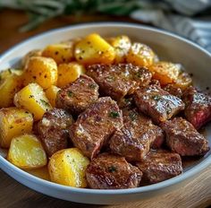 a white bowl filled with meat and potatoes