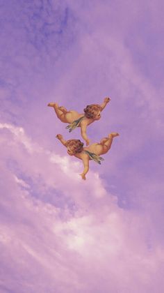 two cherubs are flying in the sky with clouds behind them and one is upside down