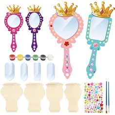 a set of three mirrors, two brushes and one comb with crowns on them next to each other