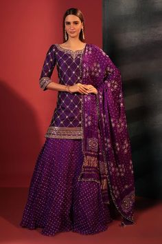 Purple kurta with gota foil embroidery in checkered pattern and leaf neckline. Paired with attached cancan skirt with bandhani woven motifs and dupatta.
Components: 3
Pattern: Embroidery, Woven
Type Of Work: Gota foil, bandhani
Neckline: Leaf neck
Sleeve Type: Three quarter
Fabric: Silk
Color: Purple
Other Details: 
Tassel embellished dupatta
Attached lining
Length:
Kurta: 36 inches
Skirt: 42 inches
Disclaimer: These are made to order designer styles, hence expect a slight variation from the ima Wedding Sharara, Designer Sharara Suits, Kurta Skirt, Shamita Shetty, Plazzo Suits, Bandhani Dress, Palazzo Suit, Sharara Suit, Anarkali Suit