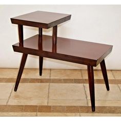 two wooden tables sitting on top of a tiled floor