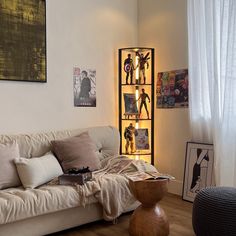 a living room filled with furniture next to a wall mounted book shelf and pictures on the wall