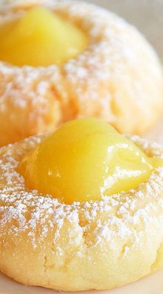 two pastries covered in powdered sugar with lemons on the top and bottom