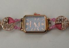 A new ladies watch with the strap replaced by a gold and pink fashion jewellery bracelet, length approx. 185mm (7.25 ins). The watch is contained in a rectangular gold coloured metal case approx 26mm x 20mm. It has a black face and gold coloured pointers and hour markers. The bracelet links are round with gold and pink patterns and are joined with pink beads. The bracelet fastens with a gold coloured double horseshoe metal fold over clasp decorated with diamantes. The watch will be despatched in Pink Bracelet Strap Jewelry For Formal Occasions, Pink Bracelet Style Jewelry For Formal Occasions, Formal Pink Jewelry With Bracelet Strap, Rose Gold Rectangular Watch With Bracelet Strap, Rectangular Rose Gold Watch With Bracelet Strap, Rose Gold Rectangular Jewelry With Bracelet Strap, Rose Gold Rectangular Bracelet Jewelry, Pink Watches With Bracelet Strap For Gift, Pink Watches With Bracelet Strap As Gift