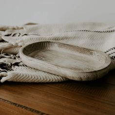 a wooden tray sitting on top of a table next to a white towel and black and white checkered cloth