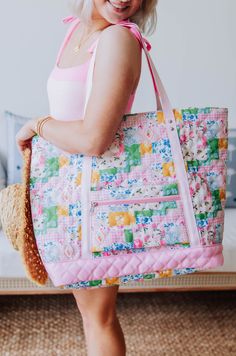 a woman is holding a colorful quilted bag in her hands and smiling at the camera