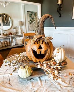 a table with pumpkins and other decorations on it, including a carved jack - o'- lantern