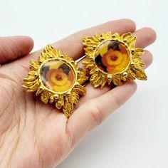 Very rare vintage Christian Lacroix flower earrings in very good condition in general. However, the clip of one earring was repaired (I put photos back to back so that you could see the difference) and it works perfectly.Brand: Christian LacroixColor: GoldtoneMaterial: There's a clear layer of resin over the flower print. Very rare find from Christian LacroixCondition: Very good conditionMeasurements: Height 4.7 cm x Width 4 cmAccessories: NoneCondition Rankings:Mint - Perfect condition and pres Vintage Metal Flower Earrings, Vintage Flower-shaped Clip-on Earrings, Handmade Retro Gold Clip-on Earrings, Handmade Gold Retro Clip-on Earrings, Vintage Clip-on Flower Earrings, Vintage Metal Flower Earrings For Pierced Ears, Vintage Flower Earrings For Anniversary, Vintage Flower Earrings For Wedding, Vintage Handmade Metal Clip-on Earrings