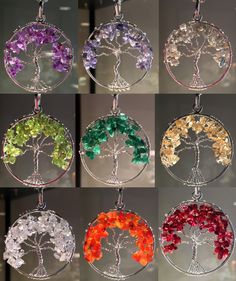 four different colored tree of life pendants hanging from glass circles with crystal stones in them