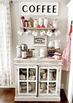 a white cabinet with dishes and cups on it in front of a sign that says coffee