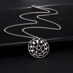 a pentagramil pendant on a black surface