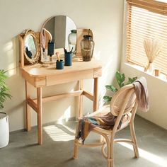 a small wooden desk with a mirror on it and a chair in front of it