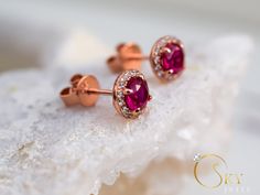 Rose gold ruby halo earrings, with a delicate yet eye capturing design. The stones have a stunning dark red color that gives you a mesmerizing effect with the accented stones all around. The Ruby is the birthstone of July. It represents love and passion. For centuries, this gem has been considered the king of all gems for its rarity, hardness (second only to a diamond), beauty and apparently mystical powers. Rubies have been the prized possession of emperors and kings throughout the ages, and to Rose Gold Bridal Earrings With Halo Design, Rose Gold Round Halo Bridal Earrings, Rose Gold Halo Earrings For Wedding, Formal Rose Gold Ruby Earrings, Round Rose Gold Earrings With Halo Setting, Rose Gold Ruby Earrings For Gifts, Rose Gold Halo Earrings For Gift, Rose Gold Halo Earrings As Gift, Rose Gold Halo Setting Earrings For Wedding