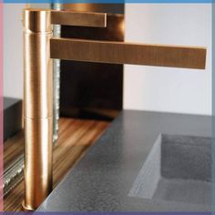 a close up of a faucet on a sink with wood and metal fixtures