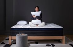 a woman sitting on top of a bed holding a pillow