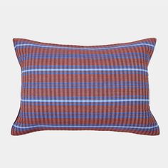 a red and blue plaid pillow on a white background