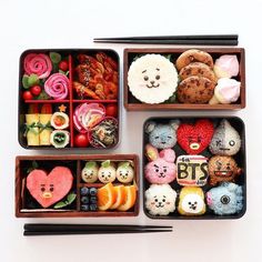 three bento boxes filled with different types of food and chopsticks next to each other