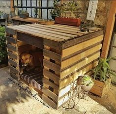 a dog house made out of pallet wood with a dog sitting in the doorway