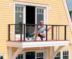 a man is sitting on the balcony of his house