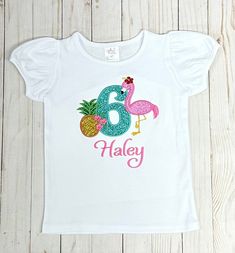 Flamingo Birthday shirt  Design features a pink flamingo with pineapple a number and a name Number 1-9 available  PROCESSING TIME IS CURRENTLY 1-3 DAYS which does not include shipping so add an additional 3-5 business days. This is a boutique quality shirt, the shirt runs true to size, is thick and very soft. The design is embroidered which means it is stitched onto the shirt for great durability and quality. Washing instructions: Machine wash cold and hang or lay flat to dry. This item was crea Pre-shrunk Pink Shirt For Birthday, Pink Birthday Shirt For Summer, Pink Summer Birthday Shirt, Pink Number Print T-shirt For Birthday, Pink Flamingo Print Short Sleeve T-shirt, Pink Short Sleeve T-shirt With Flamingo Print, Pink Short Sleeve T-shirt With Number Print, Pink Summer Tops With Name Print, Casual Pink Shirt For Birthday