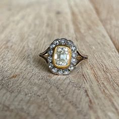 an antique diamond ring sitting on top of a wooden table