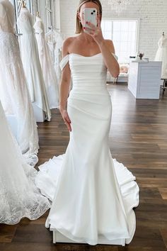 a woman is taking a selfie in her wedding dress while looking into the mirror