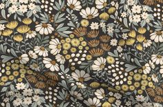 a black and yellow floral print fabric with white flowers on the front, green leaves in the back