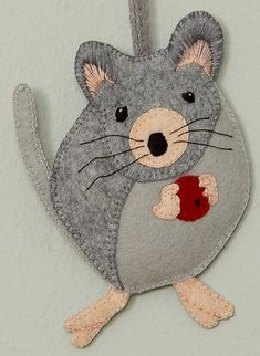 a felt mouse ornament hanging on a wall in the shape of a heart