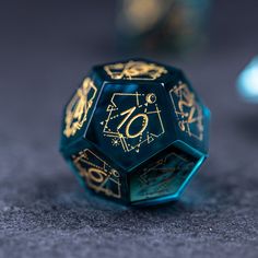 a black and gold dice sitting on top of a gray table next to other items