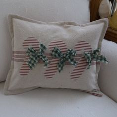 two decorative bows are on the back of a pillow that is sitting on a couch