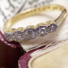 an old diamond ring sits on top of a piece of fabric