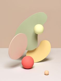 an abstract sculpture with two balls in front of it and one ball on the ground