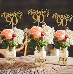 three mason jars filled with flowers sitting on top of a table next to each other