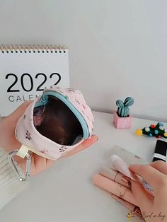 a person holding a pink hat and sunglasses on top of a white table next to a calendar