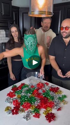 a group of people standing around a table covered in christmas candies and confetti