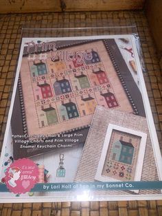 the front cover of a cross stitch pattern book, with pictures of houses on it