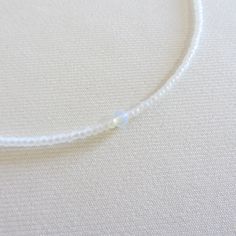 Moonstone beaded necklace, White seed bead necklace, Waterproof necklace, Tiny simple choker, Stainless steel necklace There are two clasp options, one is a stainless steel clasp and chain, the second option the clasp and chain are made of brass with 14k gold plating so the necklace will not lose its look over time! Choker is 13 inches with a 2 inches adjustable extender chain. 15 inches full length. The necklace is made with 10/0 size Czech seed beads. Measure the length of your neck with a measuring tape or you can use any thread, rope, or cable for telephone and after apply the measurements to a regular ruler. Minimalist Single Strand Beaded Necklace, Minimalist White Beaded Necklaces For Everyday, Minimalist White Beaded Necklace For Everyday, Minimalist Everyday White Beaded Necklaces, Adjustable Single Strand Crystal Choker Necklace, Adjustable Single Strand Crystal Choker, Dainty Crystal Necklaces With Tiny Beads, Simple White Round Beads Jewelry, Simple White Round Bead Jewelry