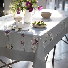 a table with flowers and plates on it