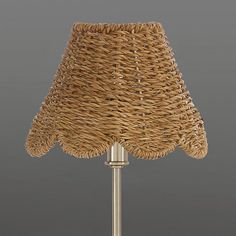 a wicker lamp shade on a metal base