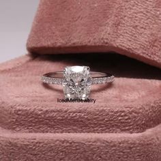 a cushion cut diamond ring in a pink velvet box