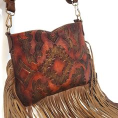 This charming Tooled Leather bag adds a vintage Western flair to your outfits with effortless ease. Handcrafted with love and care by artisans, its rustic style will make your look stand out from the rest. Perfect for a crossbody look height: 9 inches width : 11.5 inches base:1.5 inches detachable adjustable large strap: 63inches Fabric lining interior:  1  small zip compartment Exterior: 1 small  zip compartment  Zipper at the top. Exciting news!  This bag is in stock  ⏳ once this bag is sold i Country Style Brown Bag For Everyday Use, Rustic Brown Tote Bag, Vintage Textured Leather Crossbody Shoulder Bag, Artisan Brown Bag For Fall, Vintage Brown Bohemian Rectangular Bag, Vintage Brown Hand-tooled Shoulder Bag, Bohemian Crossbody Saddle Bag, Rustic Hand Tooled Bag For Everyday Use, Rustic Hand Tooled Brown Bag