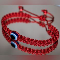 two red bracelets with blue eyes on them