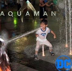 a young boy is playing in the water fountain at aquaman park, which has been opened to let kids cool off