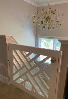 an open white door with a chandelier hanging from the ceiling