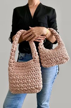 a woman holding a crocheted purse in her hands