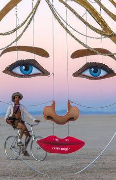 a woman riding a bike with blue eyes and lips hanging from it's sides