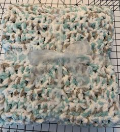 a crocheted blanket with a bow on it